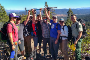 Trailworkers holding trail tool in celebration