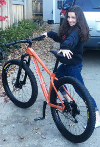 Emma smiling with her Santa Cruz Chameleon bike.