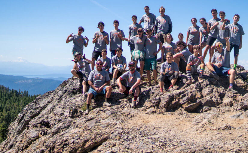 NorCal Group of kids on rocks of Mt. Hough with mountains and lakes in background