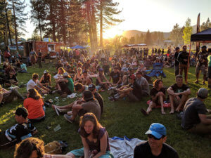 Large group of people on Portola park green with sunset