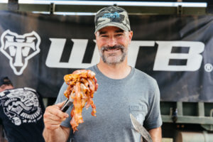 Mark Weir holding bacon at the WTB aid station.