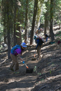 Two women digging trail