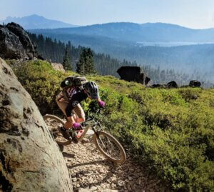 Mountain biking the Mills Peak Trail with the Lakes Basin in the background.