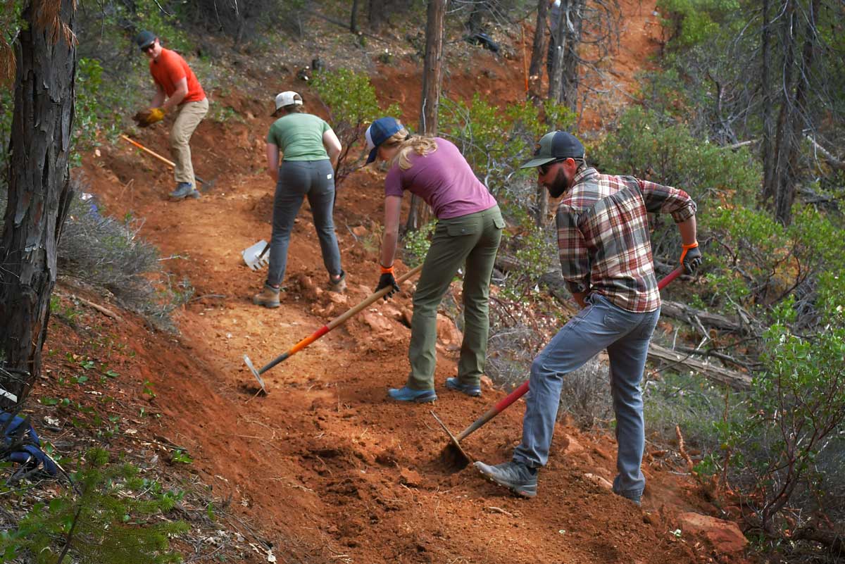 volunteers digging trail in dirt